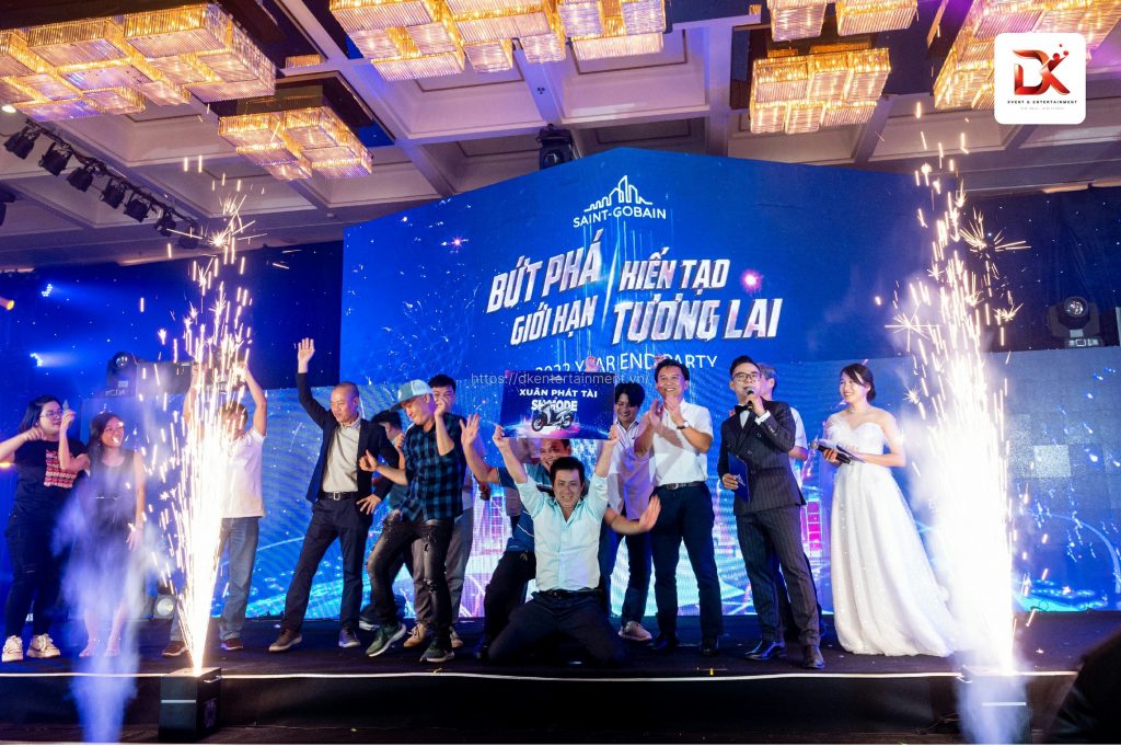 A group of employees celebrating on stage at a gala dinner event, highlighting the success of an event agency in Ho Chi Minh.