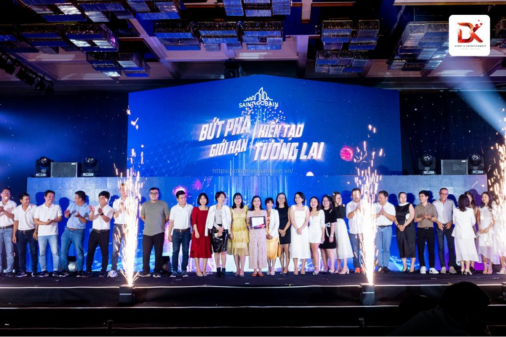 Winners holding awards and celebrating on stage during a gala dinner, organized by a top event agency in Vietnam.